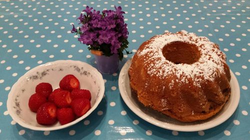 High angle view of homemade cake by strawberries on table