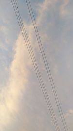 Low angle view of power lines against sky at sunset