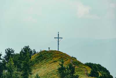 Panoramic view of cross on mountain against sky