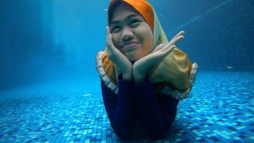 Portrait of young woman swimming in sea