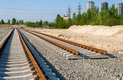 Railroad tracks by trees against sky