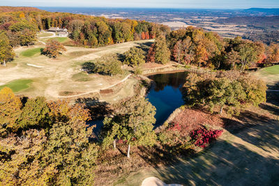 Aerial view of a mountain top golf course pond with a valley view in the background in tennessee.