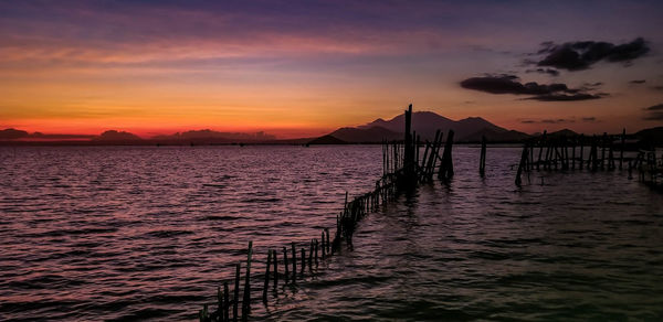 Pier over sea against sky during sunset