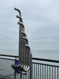 Metal railing by sea against sky. sea music, tembos.