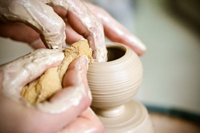 Girl sculpts in clay pot closeup. modeling clay close-up. caucasian man making vessel 