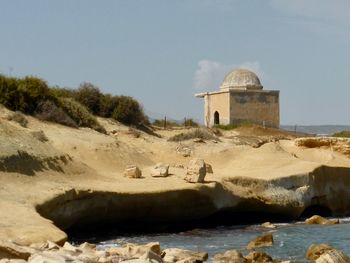 Fort at beach against sky