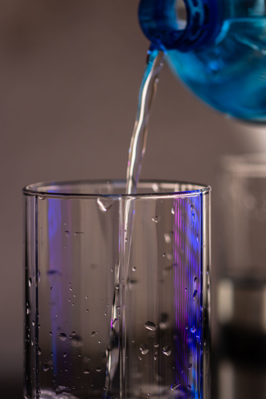 CLOSE-UP OF GLASS OF BLUE WATER