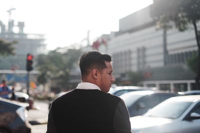 Rear view of man standing on street in city