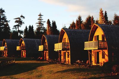 Panoramic view of houses and trees on field against sky