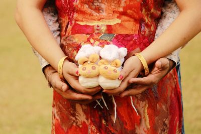 Midsection of couple holding baby botties