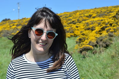 Portrait of woman wearing sunglasses on field