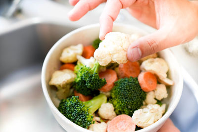 Cropped hand of woman holding food