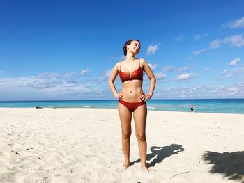 Full length of young woman standing at beach