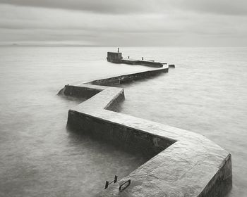 St monans zigzag shaped breakwater against cloudy sky