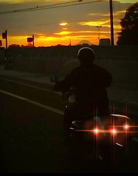 Silhouette man standing against illuminated sky during sunset