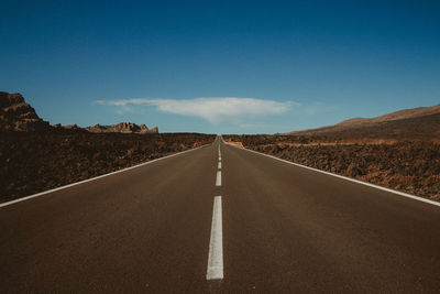 Empty road along landscape and blue sky
