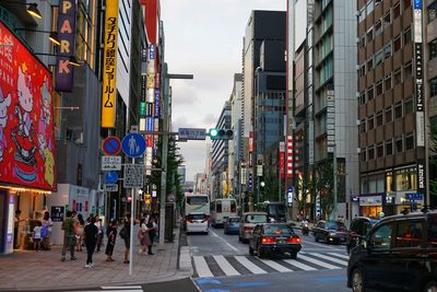 Vehicles on city street amidst buildings