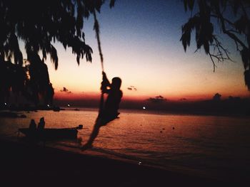 Silhouette of people on beach at sunset