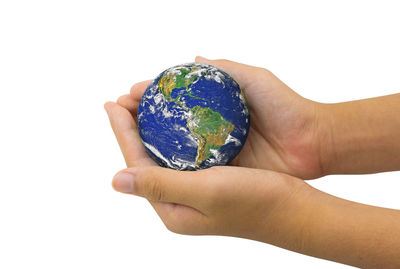 Close-up of hand holding ice cream over white background