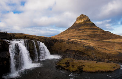 Scenic view of waterfall against sky