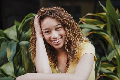 Portrait of a smiling young woman sitting outdoors