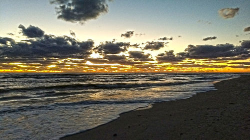 Scenic view of beach against sky during sunset