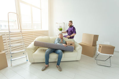 Rear view of couple sitting on floor at home