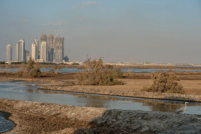 River by buildings against sky in city