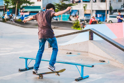 Rear view of man skateboarding on skateboard