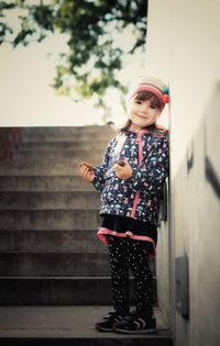 Happy girl with cookies standing on steps