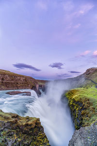 Scenic view of waterfall against sky