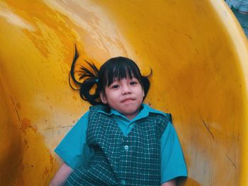Portrait of cute girl on yellow slide