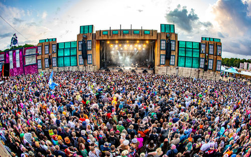 Group of people at music concert against sky