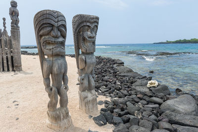 Sculpture of rocks on beach against sky