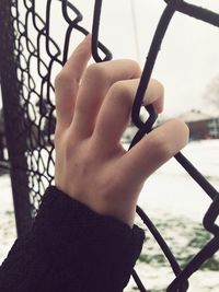 Close-up of hand holding finger against sky