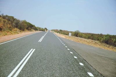 Empty road along trees