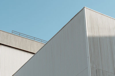 Low angle view of modern building against clear blue sky