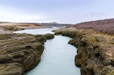 Scenic view of river amidst mountains against sky