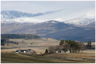 Scenic view of field and mountains against sky