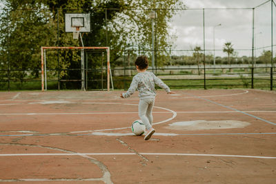 Rear view girl playing football