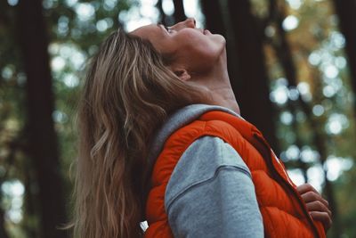 Midsection of woman against trees in forest