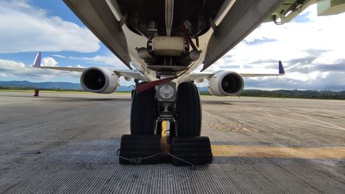 Airplane on airport runway against sky