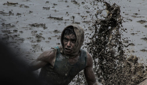 Portrait of shirtless man in sea