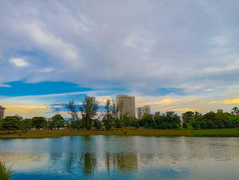 Scenic view of river by buildings against sky
