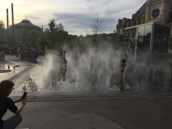 People on street against sky in city