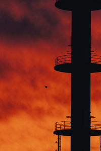 Low angle view of silhouette tower against sky during sunset