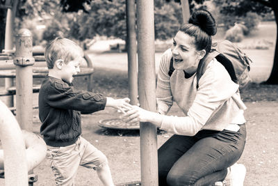 Happy mother and son playing on ground