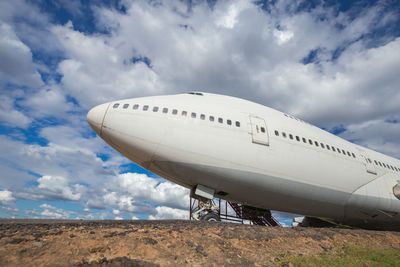 Low angle view of airplane on land against sky