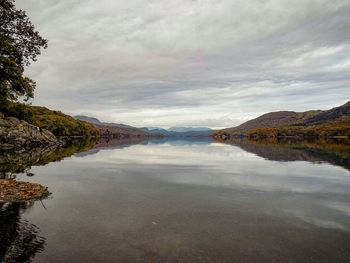 Scenic view of calm lake against cloudy sky