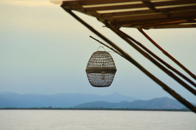 A hanging lamp light against the sea and mountain silhouettes in kep, cambodia